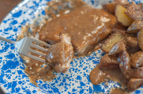 These Fried Smothered Pork Chops from Farmwife Feeds are an easy recipe using boneless chops that cook quickly and get supper on the table fast. #pork #castiron #gravy