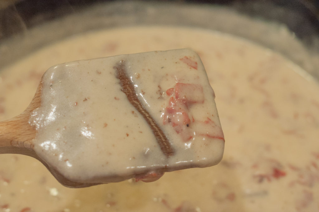 close up of creamy chipped beef gravy on spoon showing texture