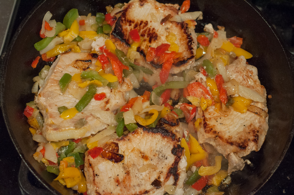 Easy Skillet Peppers, Onions and Pork Chops from Farmwife Feeds is an easy meal using frozen pepper and onion mix and boneless pork chops. #pork #recipe #porkchops