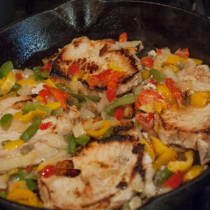 Easy Skillet Peppers, Onions and Pork Chops from Farmwife Feeds is an easy meal using frozen pepper and onion mix and boneless pork chops. #pork #recipe #porkchops