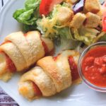 Easy pepperoni crescent roll calzones with mozzarella cheese, served with salad and marinara sauce - perfect kid-friendly meal