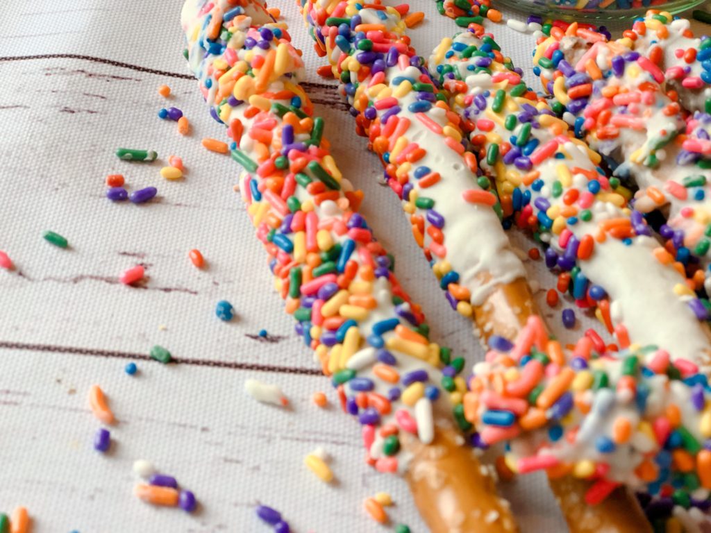 Funfetti White Chocolate Dipped Pretzels from Farmwife Feeds are full of sprinkle, white chocolate, cake mix and the saltiness of the pretzel for a fun snack or treat. #whitechocolate #sprinkles #saltysweet #pretzel #treat