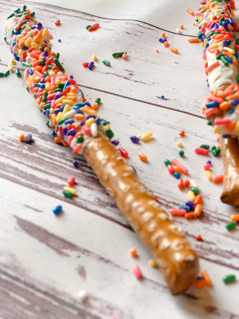 Funfetti White Chocolate Dipped Pretzels from Farmwife Feeds are full of sprinkle, white chocolate, cake mix and the saltiness of the pretzel for a fun snack or treat. #whitechocolate #sprinkles #saltysweet #pretzel #treat
