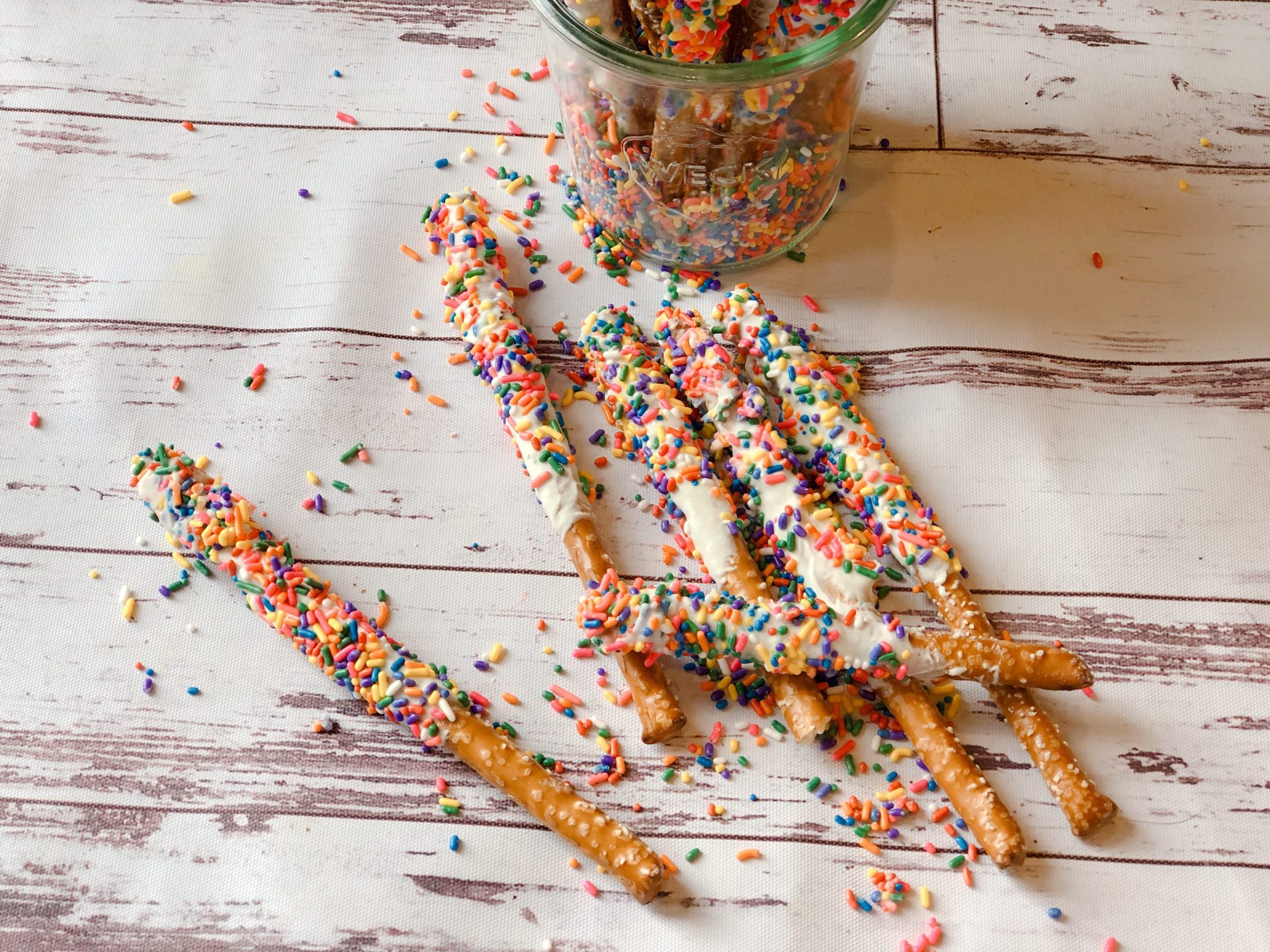 Funfetti White Chocolate Dipped Pretzels from Farmwife Feeds are full of sprinkle, white chocolate, cake mix and the saltiness of the pretzel for a fun snack or treat. #whitechocolate #sprinkles #saltysweet #pretzel #treat