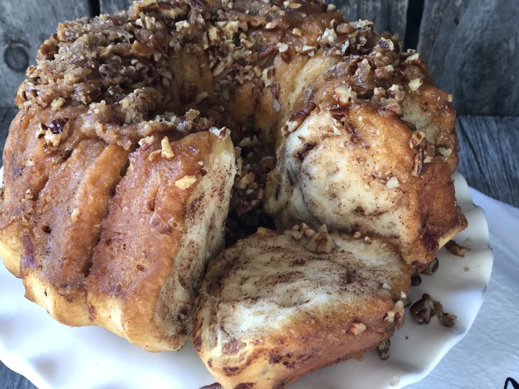 Easy Caramel Cinnamon Roll Bundt Cake from Farmwife Feeds makes a pop can of cinnamon rolls into a delicious easy bundt cake with a caramel glaze and pecans. #cinnamonrolls #bundtcake #easybreakfast