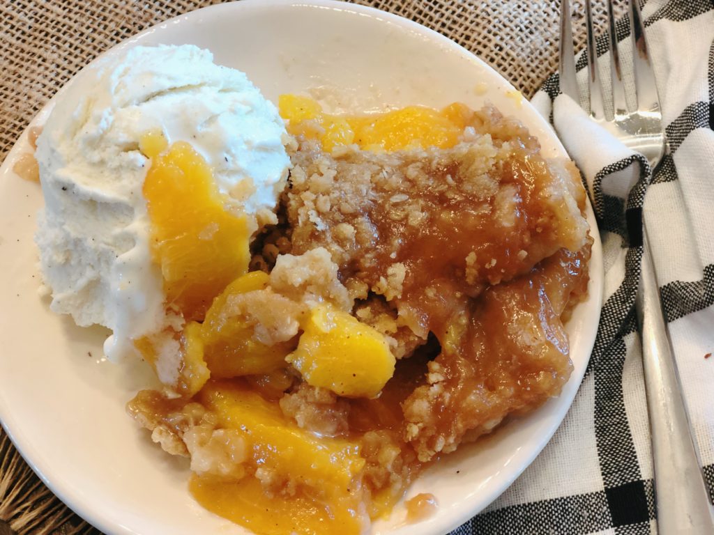 Spiced Rum Peach Crisp from Farmwife Feeds is the perfect fresh peach dessert with a spicy warmness that pairs perfect with ice cream. #peachcrisp #peaches #fruit