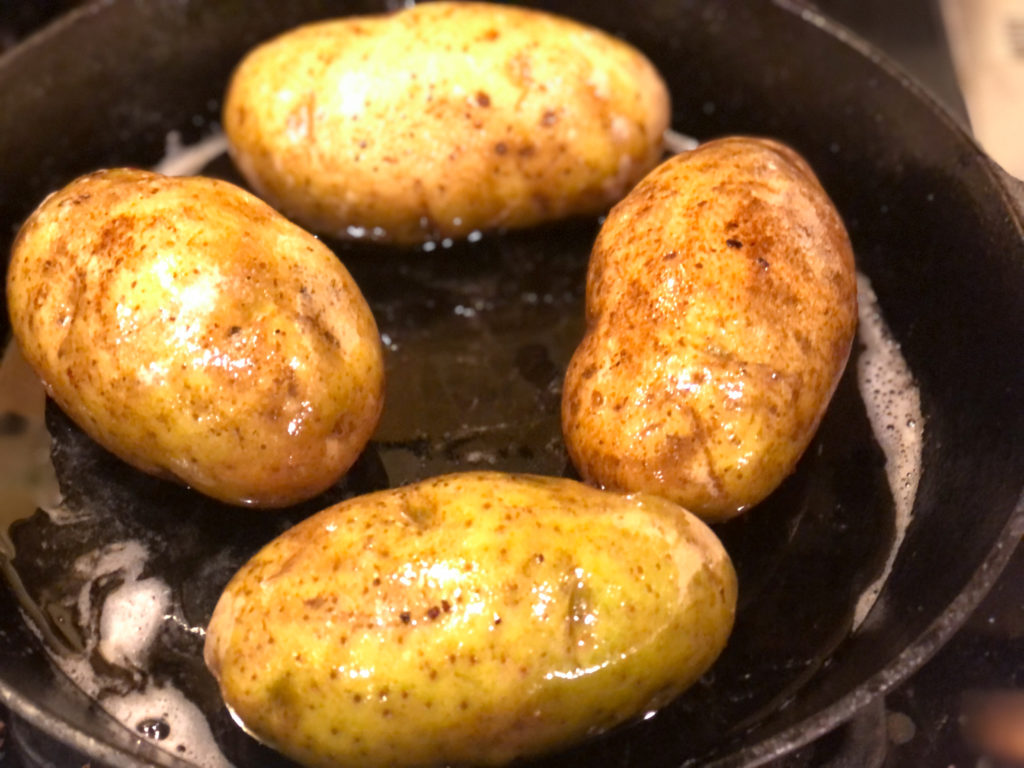 4 whole potatoes with skin on in a cast iron skillet