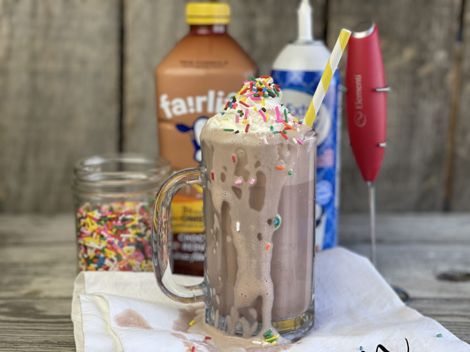 Cade's Perfect Chocolate Milk, Fairlife Chocolate Milk is frothed then topped with whipped cream and sprinkles. A sweet filling snack with a protein packed milk that is delicious and healthy. #milk #chocolate #fairlife