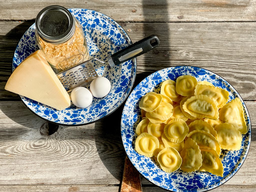 2 bowls a bowl of refrigerator ravioli unprepared a bowl with mason jar of panko, pagamason block 2 eggs micro grater