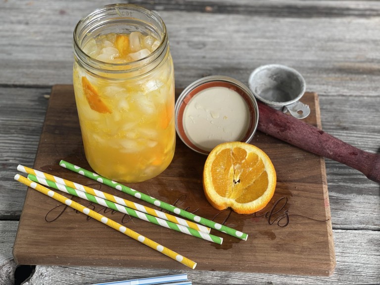Glass of an Orange Shake-up with orange slice, crushed ice and straws