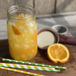 Glass of an Orange Shake-up with orange slice, crushed ice and straws
