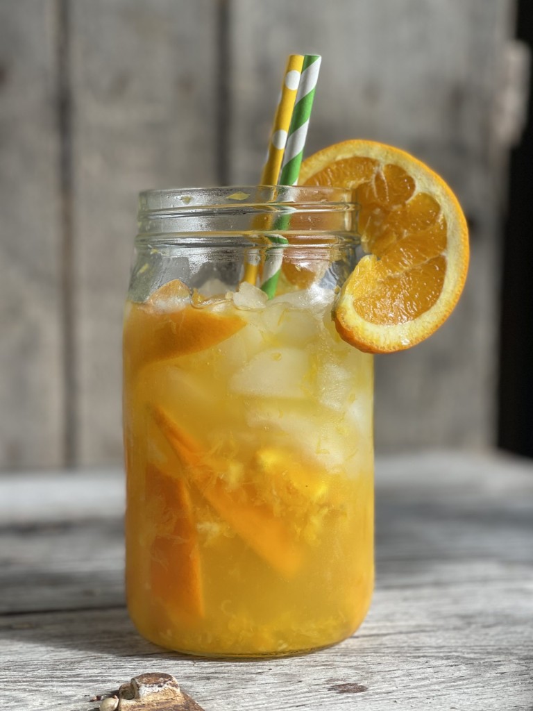 Glass of an Orange Shake-up with orange slice, crushed ice and straws