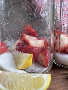 mason jar with strawberry pieces and slice of lemon with granulated sugar