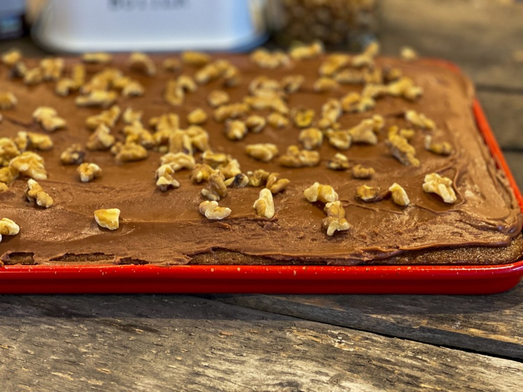 uncut Chocolate Texas Sheet Cake in a red jelly roll pan with walnuts on top