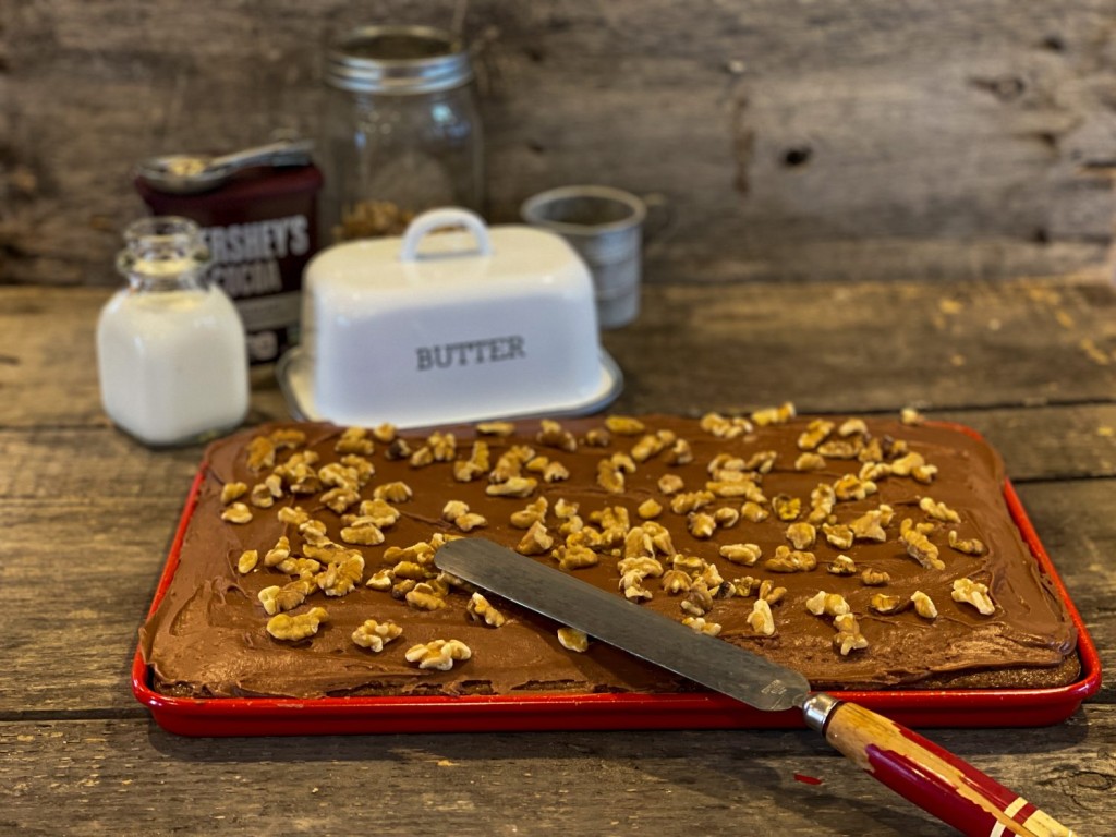 uncut Chocolate Texas Sheet Cake in a red jelly roll pan with walnuts on top