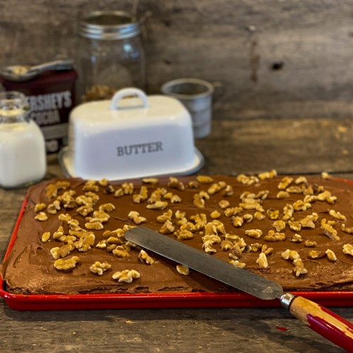 uncut Chocolate Texas Sheet Cake in a red jelly roll pan with walnuts on top