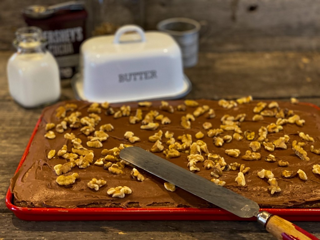 uncut Chocolate Texas Sheet Cake in a red jelly roll pan with walnuts on top