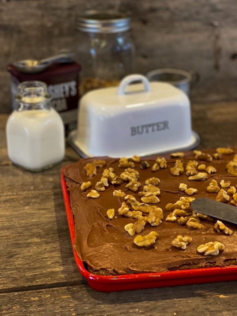 uncut Chocolate Texas Sheet Cake in a red jelly roll pan with walnuts on top