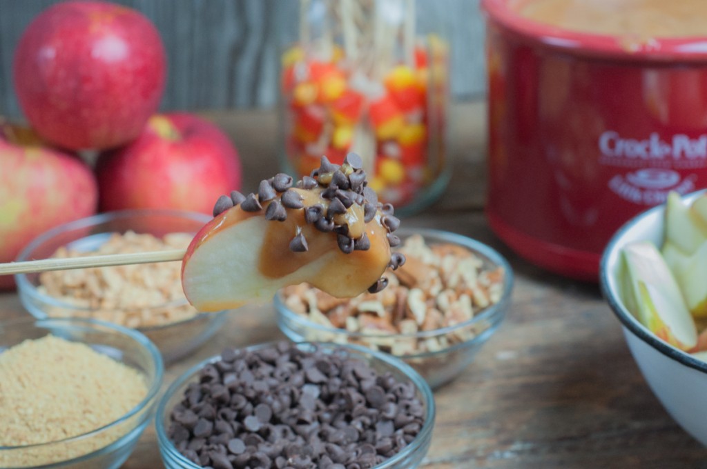 Apple slice dipped in caramel and coated with mini chocloate ships from a caramel apple dip bar.
