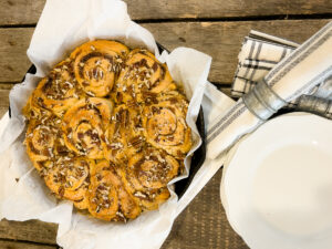 Overhead view of baked TikTok cinnamon rolls with pecans in a cast iron skillet