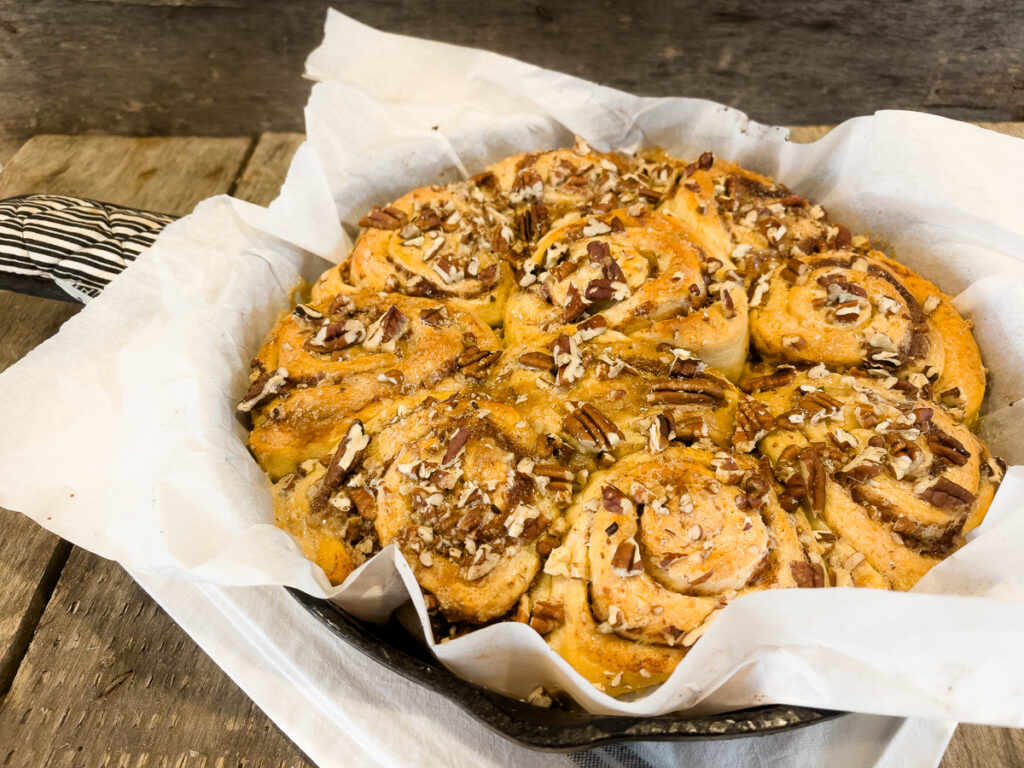 Viral TikTok cinnamon rolls baked in a cast iron skillet with heavy cream, brown sugar, and pecans