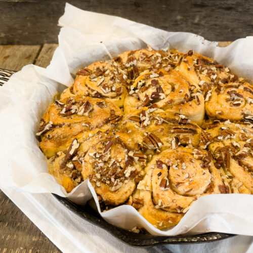 Viral TikTok cinnamon rolls baked in a cast iron skillet with heavy cream, brown sugar, and pecans